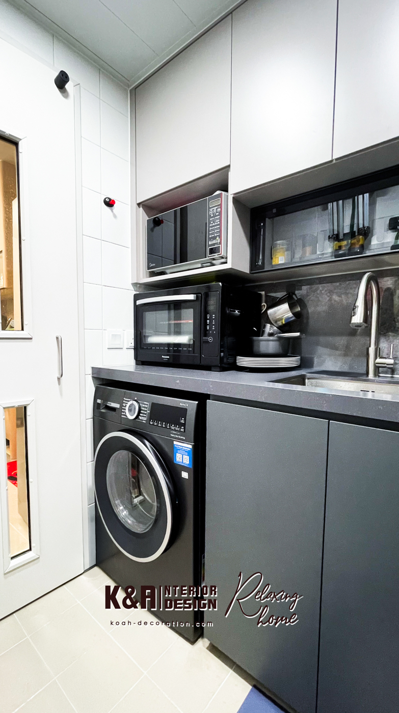 【廚房設計】經典L形廚房設計之下，以中灰調大理石紋理石材與暖白、深灰高質板材建構，盡顯高貴氣派，尺寸精準的訂造廚櫃組合，為戶主提供便利的入廚體驗，其中工作枱上強化玻璃吊櫃以「上翻門」設計，更便利於日常