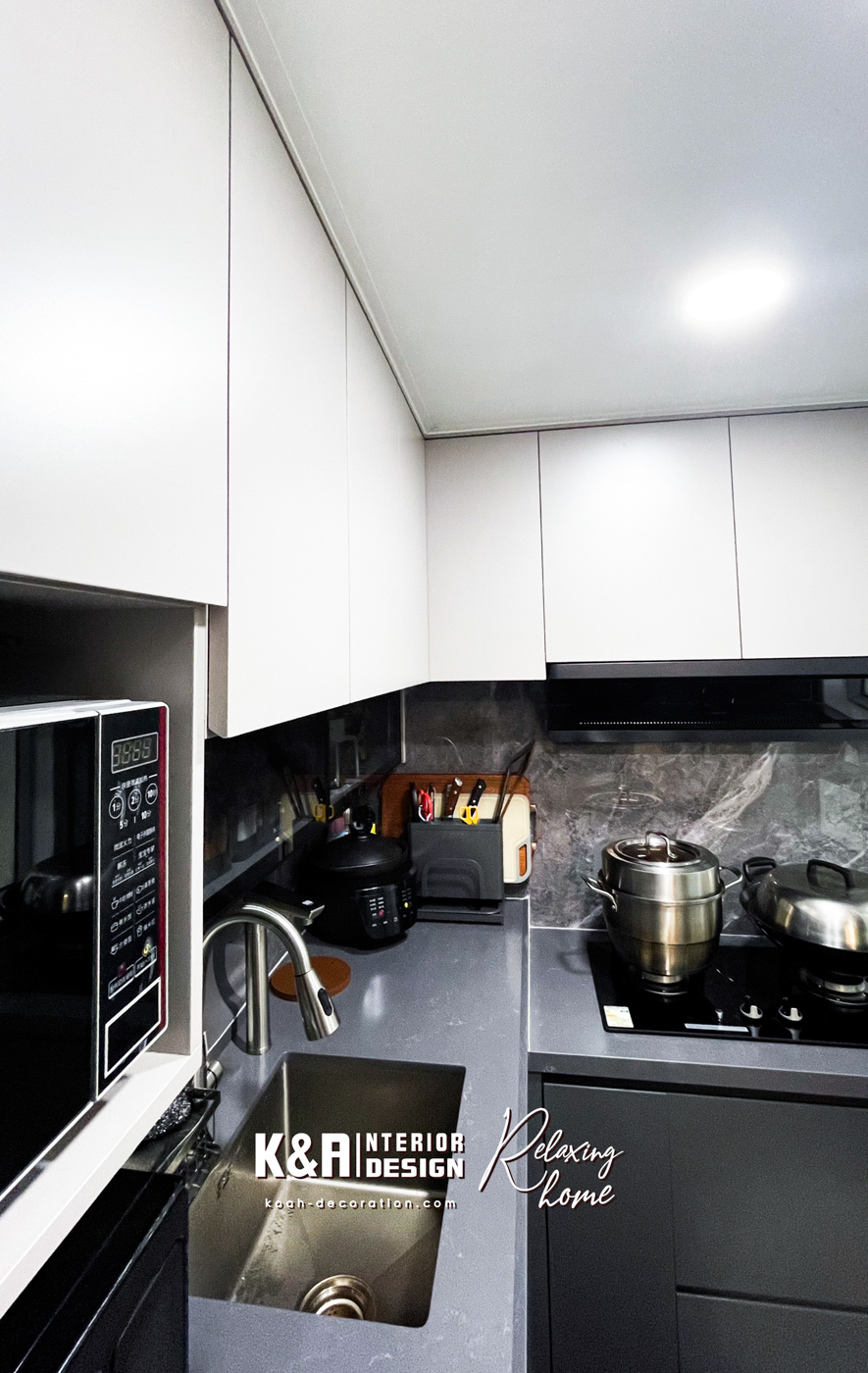 【廚房設計】經典L形廚房設計之下，以中灰調大理石紋理石材與暖白、深灰高質板材建構，盡顯高貴氣派，尺寸精準的訂造廚櫃組合，為戶主提供便利的入廚體驗，其中工作枱上強化玻璃吊櫃以「上翻門」設計，更便利於日常