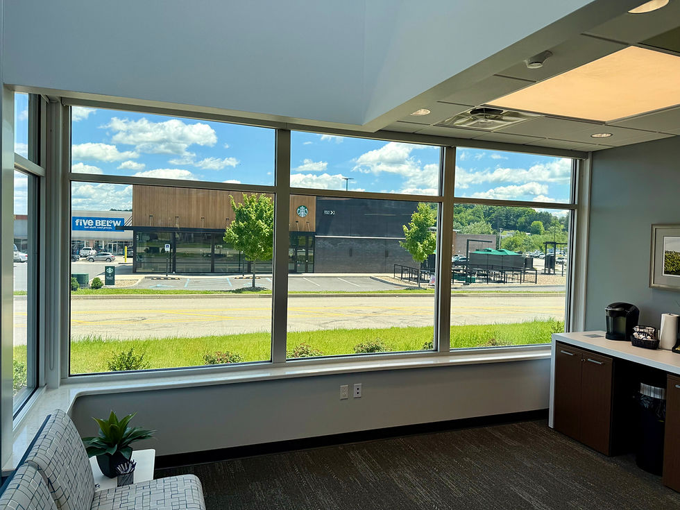 Bright office waiting room with large windows overlooking Starbucks and Five Below under a blue sky with clouds in White Hall WV. Windows Tinted by Shade9