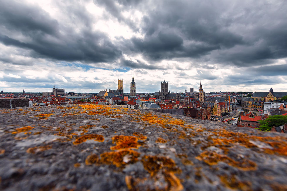 Beneath a sky heavy with storm and light, the city of Ghent stretches out like a story etched in time. Its towers pierce the horizon, standing proud against the gathering clouds. From this vantage point, with the ancient stone in the foreground, it feels as though the city breathes history — quietly, powerfully, waiting to be heard.

Location 
- Ghent, Belgium