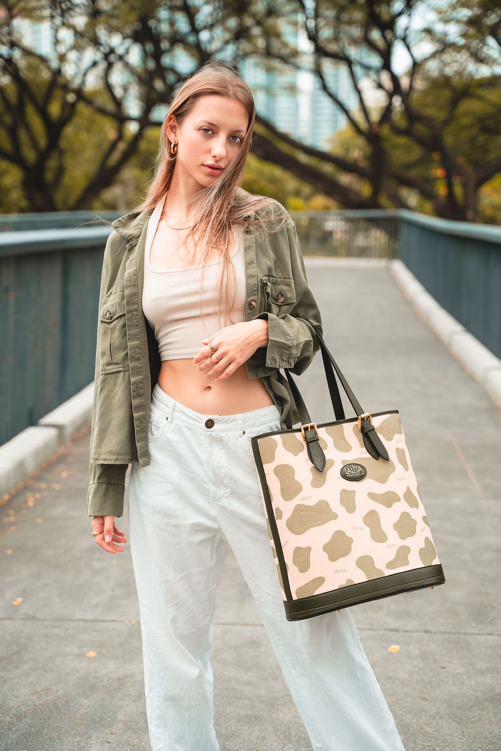 Young woman poses with a patterned tote bag on a bridge, LALITA.