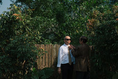 An older man adjusts a groom's tie outdoors – Da Nang