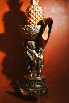 Red Steve Madden heels on a golden cherub statue – Binh An Village, Vung Tau