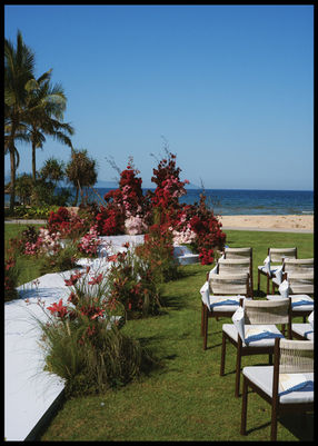 Beachfront wedding ceremony with red floral arrangements – Hoiana Resort