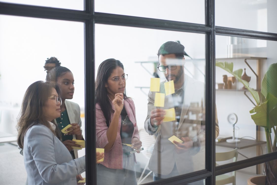 Stock photograph of colleagues planning together with notes on a wall