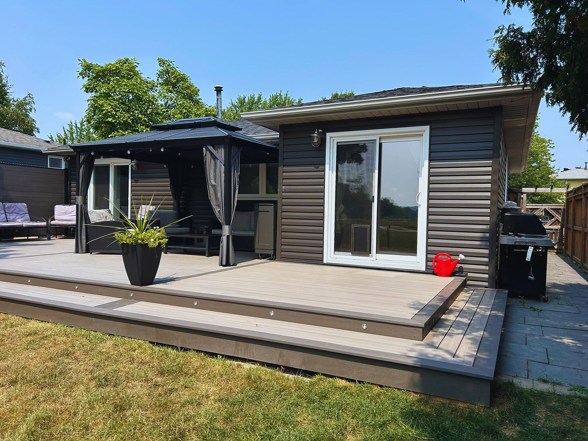 Beautiful backyard transformation featuring a custom fence, deck, and landscaped outdoor living space in Ontario.