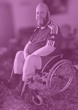 Pete, smiling at the camera, sitting in a wheelchair.