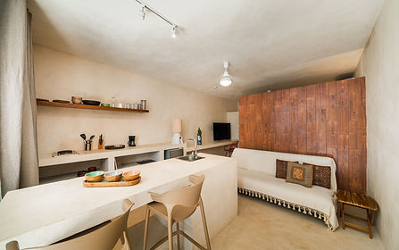 Kitchenette area in boutique hotel room in La Manzanilla, Mexico with coffee maker, mini fridge, and natural finishes