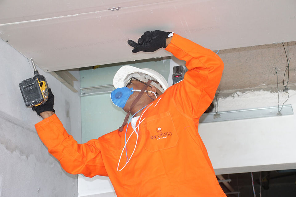 Instalação de gesso no teto de apartamento em construção.
