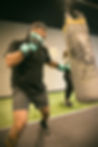 Man wearing teal boxing gloves training with a punching bag at Beyond Fitness LA gym