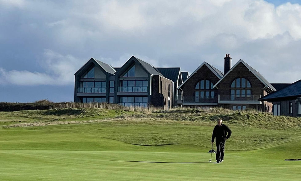 The apartment complex from the golf course with a golfer walking.