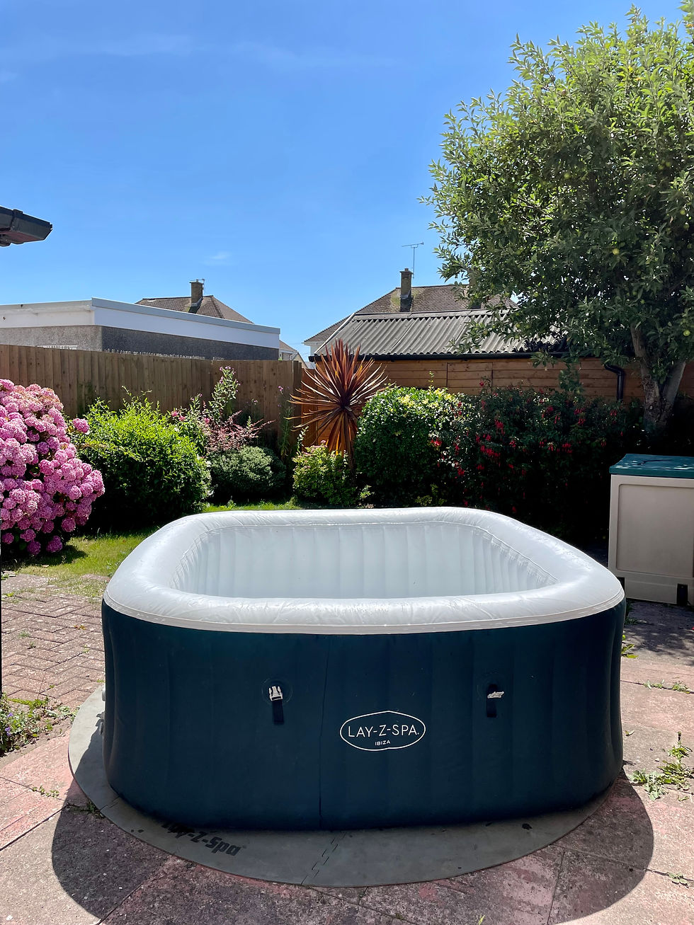 a blow up hot tub in a garden with blue sky