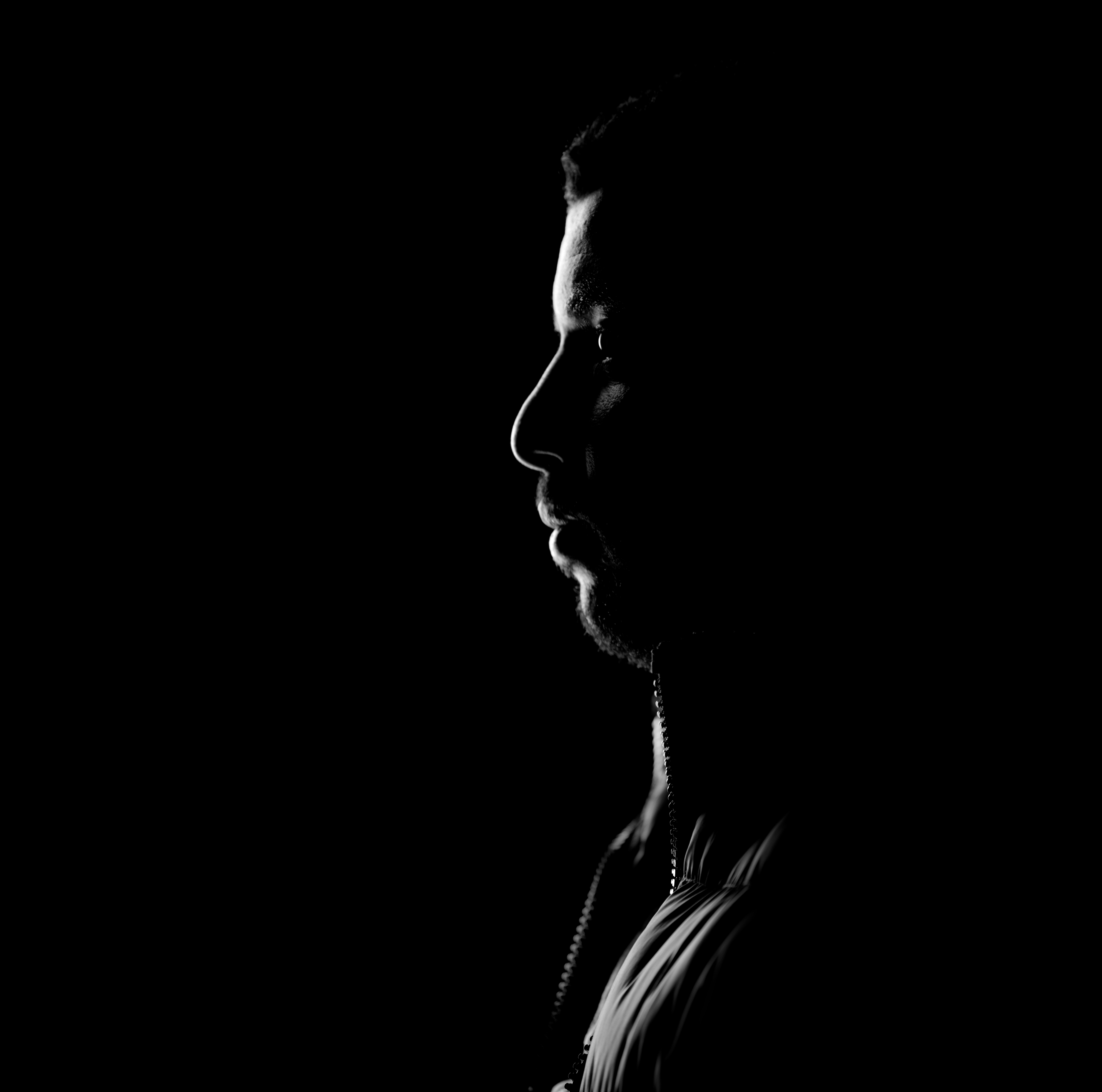 side-view-thoughtful-young-man-looking-away-against-black-background.jpg