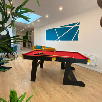 Modern room with red pool table and blue wall art