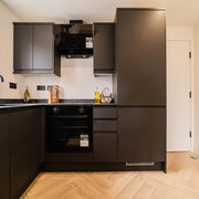 Modern matte black kitchen cabinets with black oven