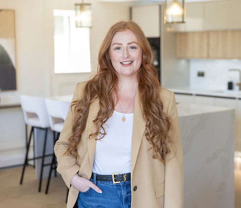 Smiling woman with long red hair in a modern kitchen