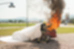 A red car on fire while Renovo Energy's fire isolator blanket is used to contain the fire and toxic fumes.