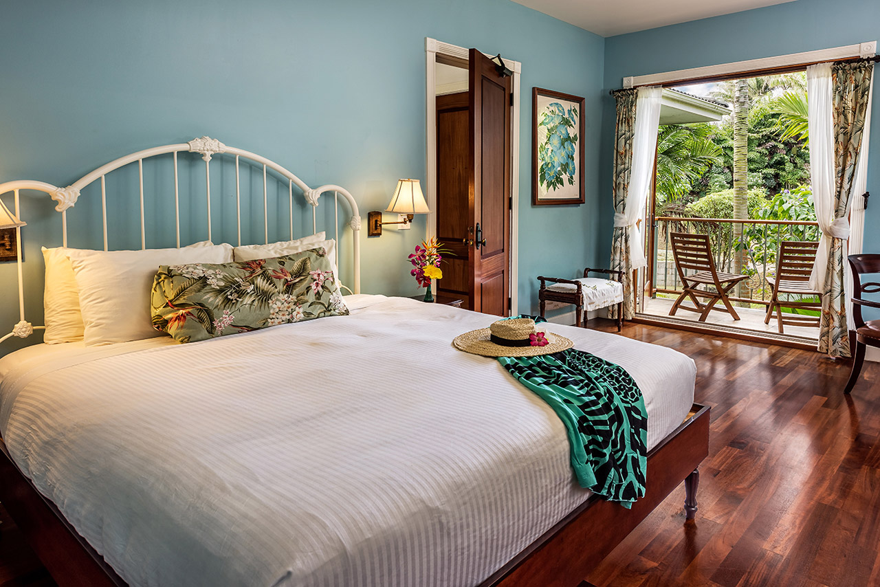Tropical bedroom with white bed frame and balcony view