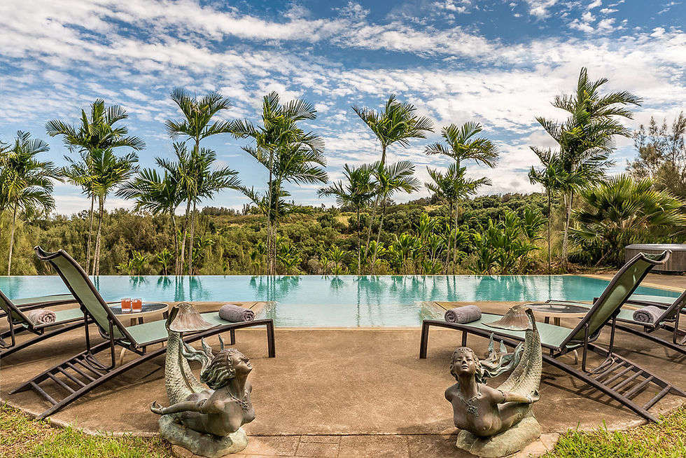 Infinity pool with lounge chairs and mermaid statues.