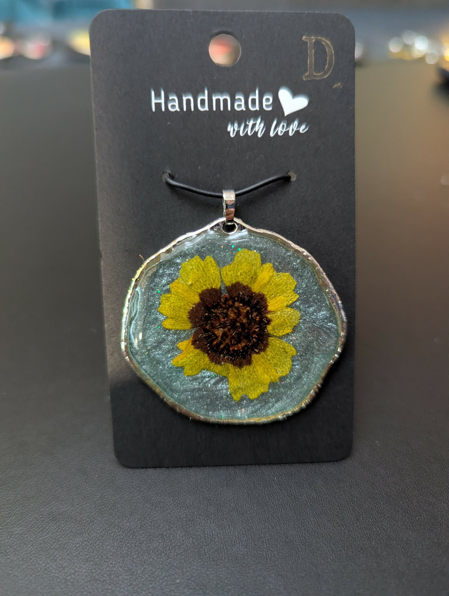 Schmuckanhänger mit gelber Blüte