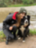 A dog trainer is smiling with a border collie