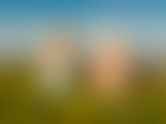 Zwei Kinder sitzen am Wattenmeer und beobachten die Gezeiten