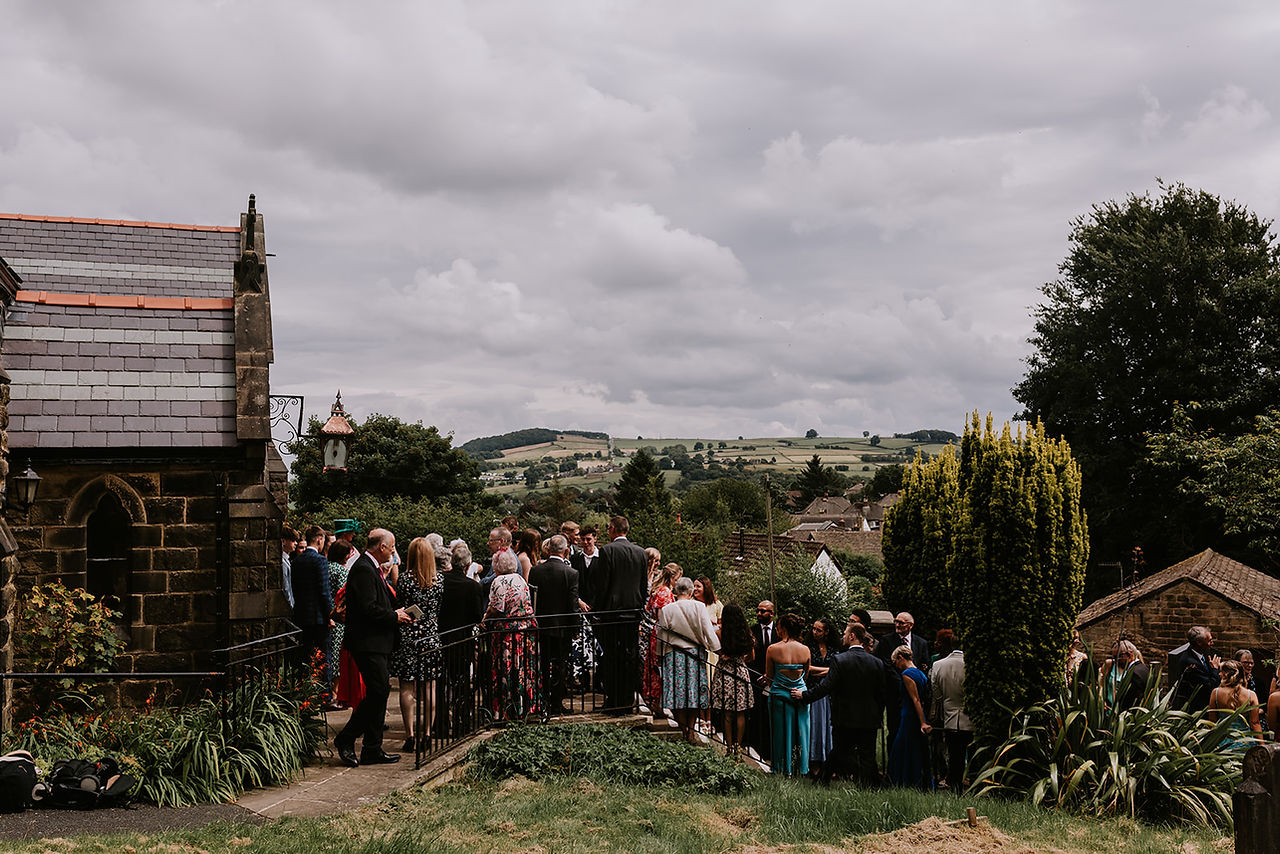Wedding guests are lining the church steps ready to greet the couple as they make their exit from the church.