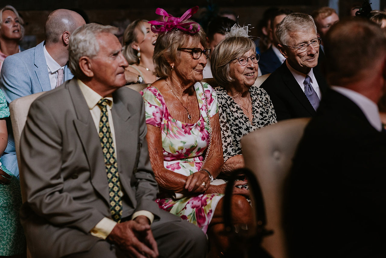 The wedding guests are all smiling and laughing during the ceremony at Wharfedale Grange.
