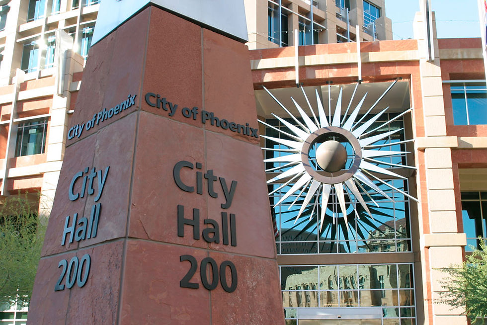 Pillar in front of the City of Phoenix City Hall building with metallic sun art work on building in background