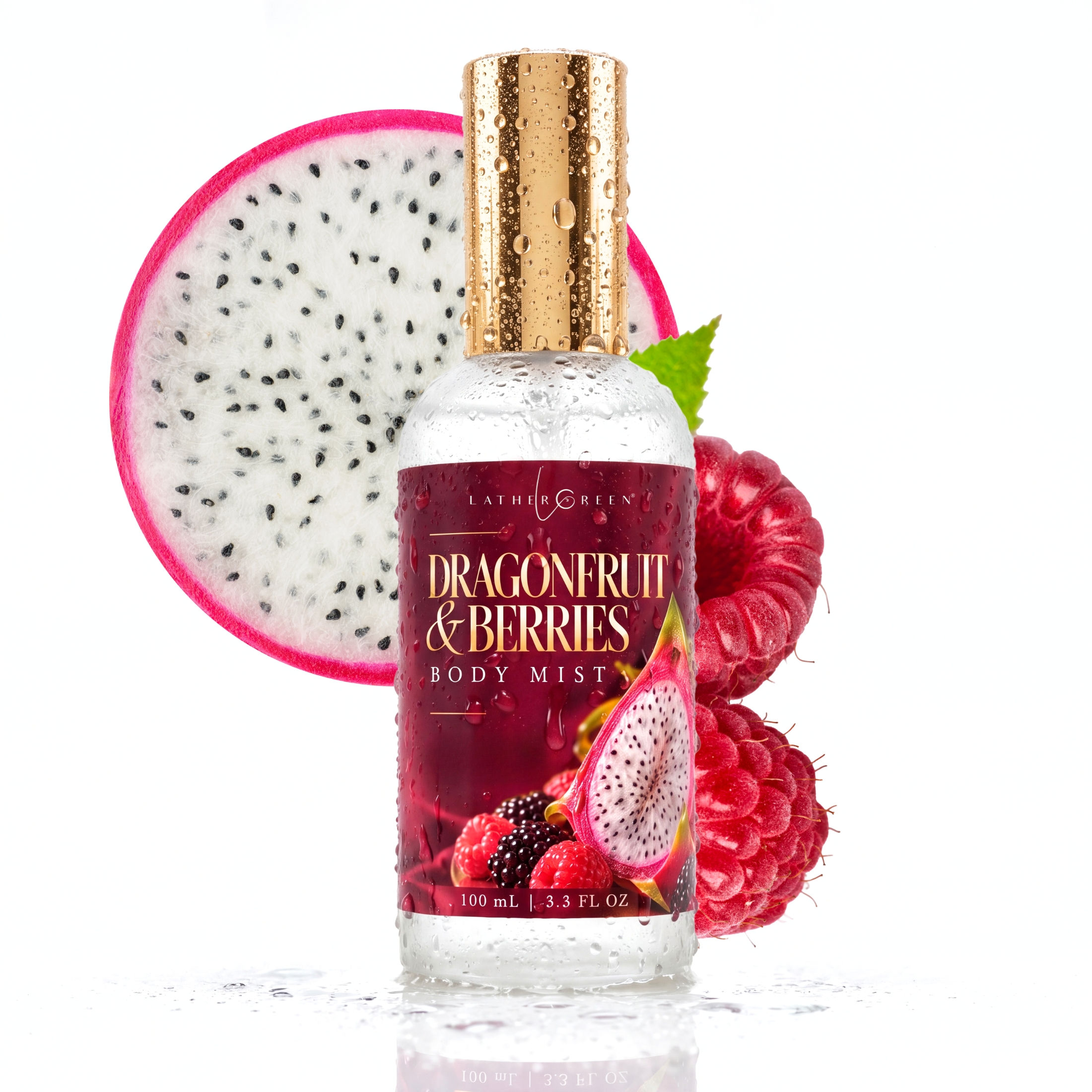 LatherGreen Dragonfruit & Berries Body Mist bottle beside sliced dragonfruit and berries on a white background.