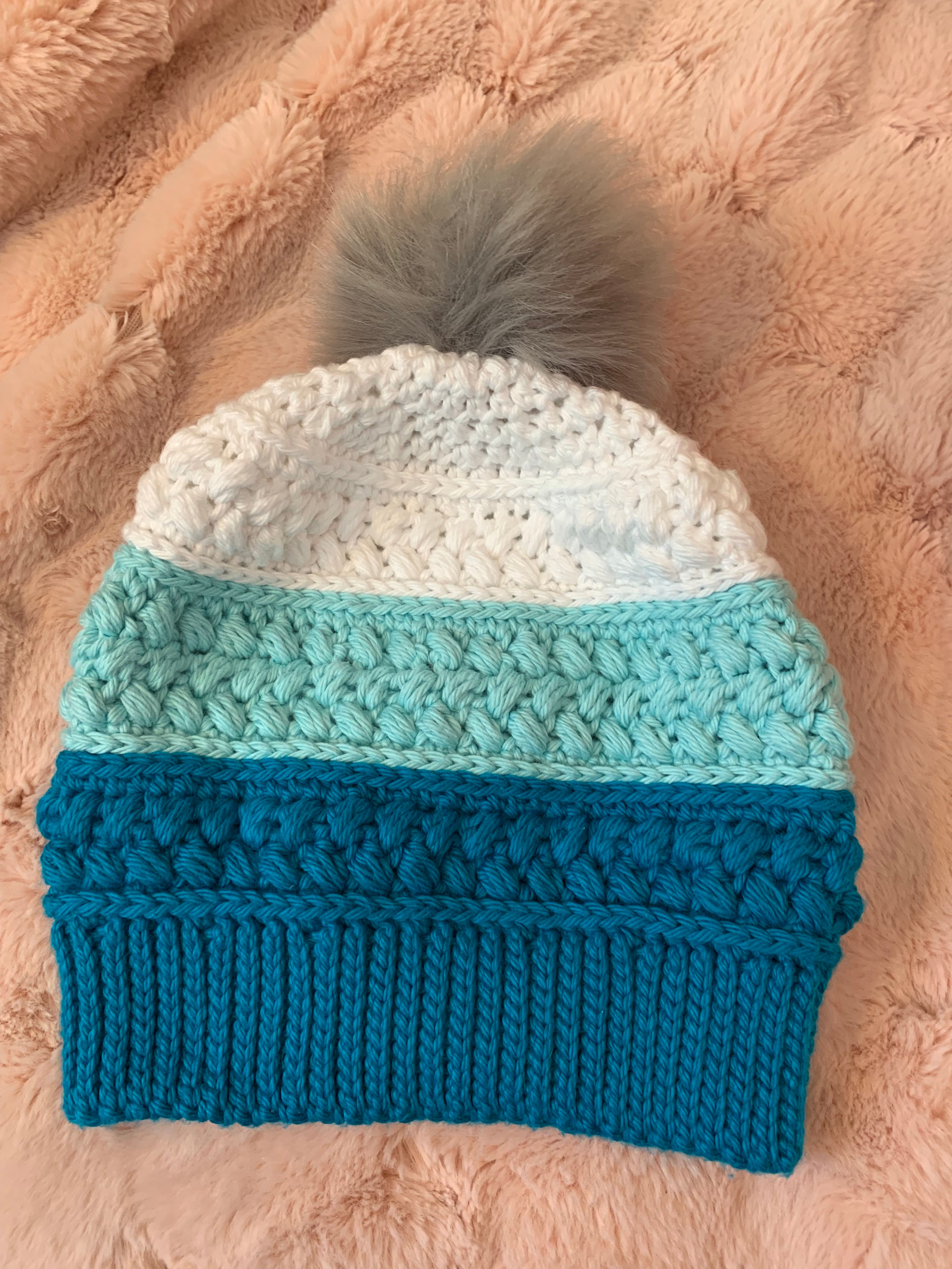 Turquoise, teal, and white hat with pom