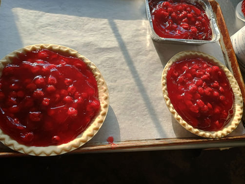 Cherry pies on a tray, a small dish, and fresh produce. Home.