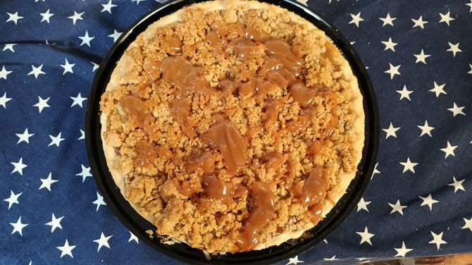 Delicious apple crumble dessert, caramel sauce drizzled on top, fresh produce.