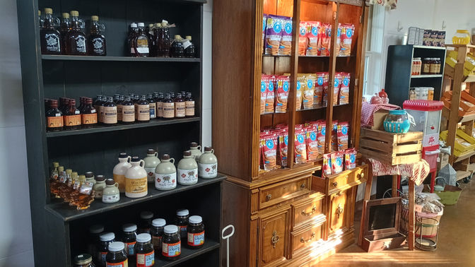 Shelves holding various jars and bottles of product on display inside store setting.