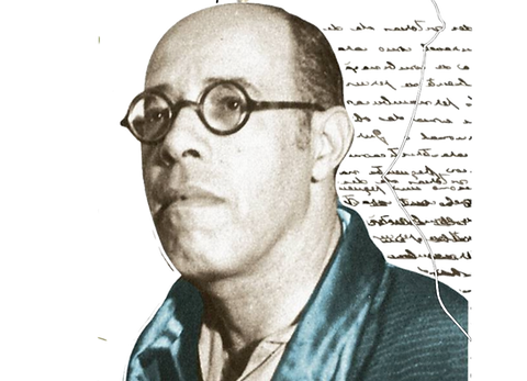 fotografia recortada, em preto e branco, do busto de Mário de Andrade de perfil esquerdo. Ele é um homem de cabelos bem curtos, escuros, com grandes entradas na testa, olhos pequenos, lábios grossos e queixo proeminente. Usa óculos de grau de aros redondos. Usa uma espécie de kimono brilhante em verde azulado.