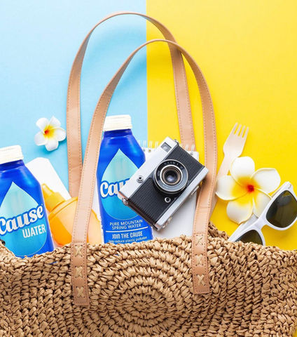 Cause Water can in a basket with sunglasses and a camera