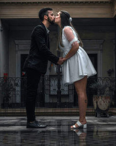 Bride and groom kissing in the rain