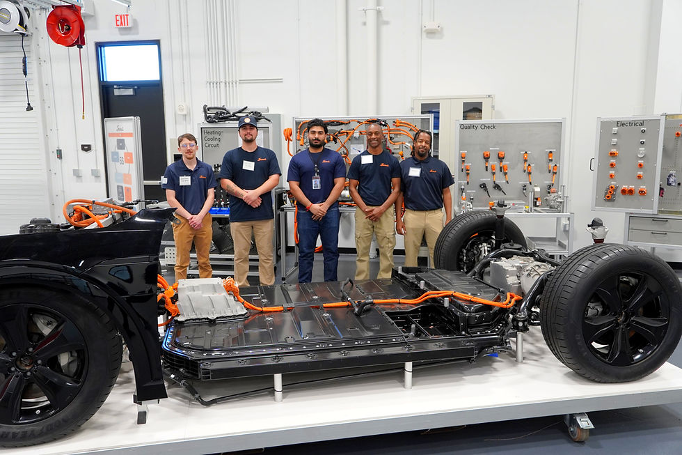 Production training staff stand inside Scout Motors’ newly unveiled training facility in Blythewood, positioned behind a battery platform and Harvester range extender frame, highlighting the hands-on learning environment designed to prepare South Carolina’s future manufacturing workforce.