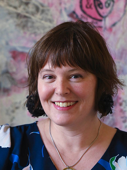 headshot of artist in front of mixed media art