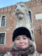 White old woman in front of a sculpted lion