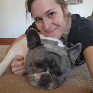 DB Pet Sitter hugging a white and grey pug who is laying on the floor