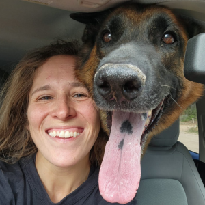 DB Pet Sitter with her head next to the head of a german shepard whose tongue is hanging out. He looks very happy. 
