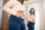 young-woman-in-a-beige-blouse-examining-her-abs-2023-11-27-05-19-36-utc.jpg