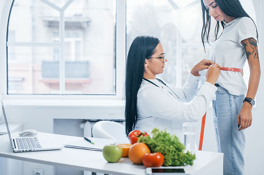 female-nutritionist-measuring-waist-of-patient-by-2021-08-28-22-40-38-utc.jpg