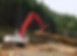 Excavator moving logs in forest