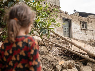 A six-year-old girl looks at the ruins of her home, destroyed in the 31 August earthquake in eastern Afghanistan