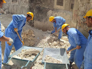 A group of workers remove rubble from a damaged neighbourhood in Syria.