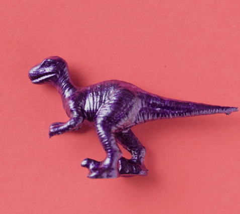 A child's purple toy dinosaur. Pediatrician assesses child's development during play at home in the childs safe enviroment.