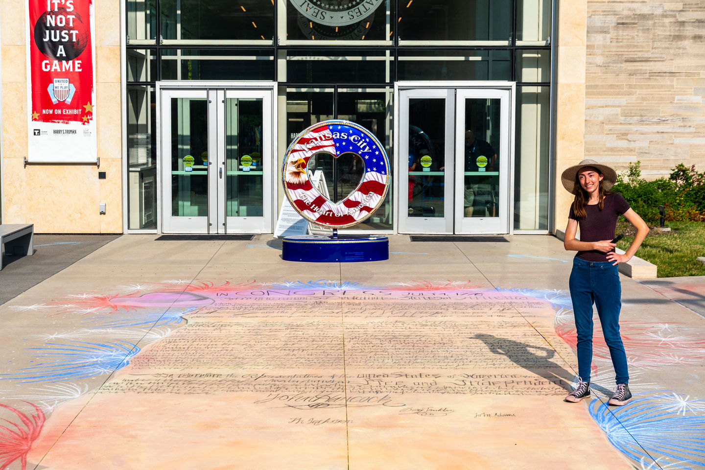 Kamilla poses her finished public works project a large scale chalk mural of the Declaration of Independence.