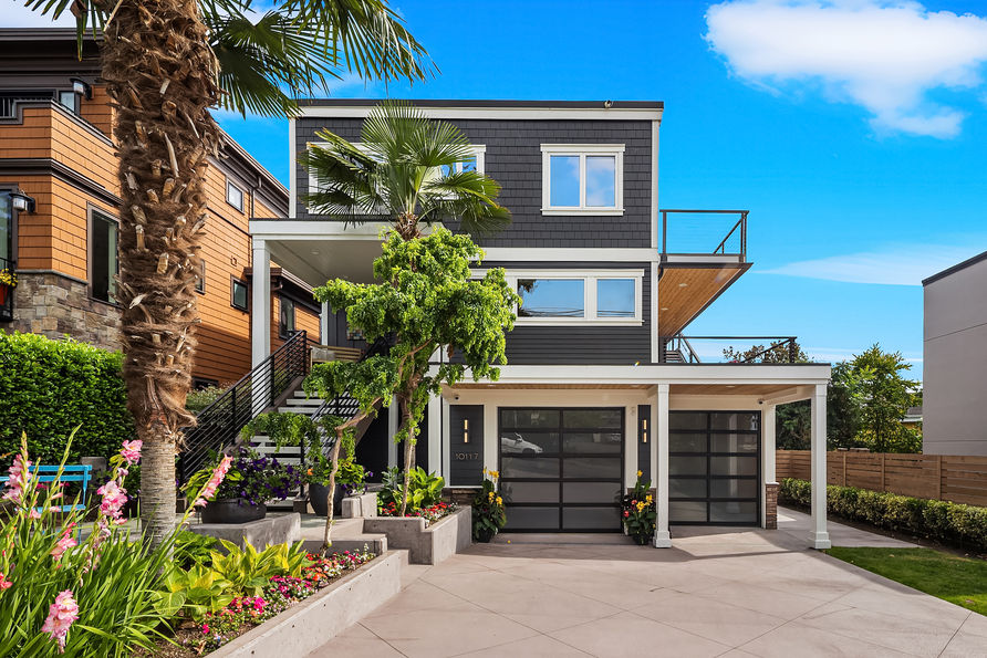 Steps from the shores of Lake WA, this beautifully renovated home invites you to experience one of Kirkland's most coveted lifestyles, where morning paddle boarding, sunset strolls along Lake WA Boulevard, & evenings at Carillon Point are just moments from your door. Thoughtfully updated throughout, the home is filled with natural light & designed for effortless indoor outdoor living with multiple view decks that embrace the surrounding scenery. Cherry hardwood floors & expansive windows frame the great room & dining area, flowing to a large covered entertaining deck that wraps around the side of the home. The elegant kitchen features timeless white cabinetry, granite countertops, stainless steel appliances, generous island storage, & abundant natural light. Upstairs, the spacious primary suite offers a custom walk in closet, adjoining office with French doors, & private covered deck showcasing sweeping 180 degree views of the lake & Seattle skyline. The lower level provides additional flexibility with 2 beds, wine storage, soaring ceilings & direct access to the backyard, creating the perfect space for everyday living. Outside, the beautifully landscaped, fully fenced backyard offers a private outdoor retreat with space to entertain. Updated with irrigation, security, cameras, indoor & outdoor speaker wiring, built-in vacuum, motorized shades throughout, & more, this home is as functional as it is beautiful, just moments from the lake & waterfront parks.